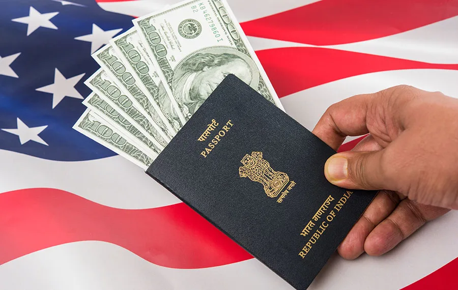 Indian Passport With Us Dollars With American Flag In The Background, Concept Showing Applying For Tourist Or H-1B Visa